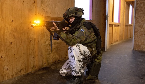 Kuvassa sotilas ampuu rynnäkkökiväärillä rakennuksessa