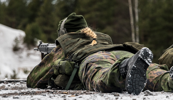 kuva jossa nainen ampuu rynnäkkökiväärillä ampumaradalla