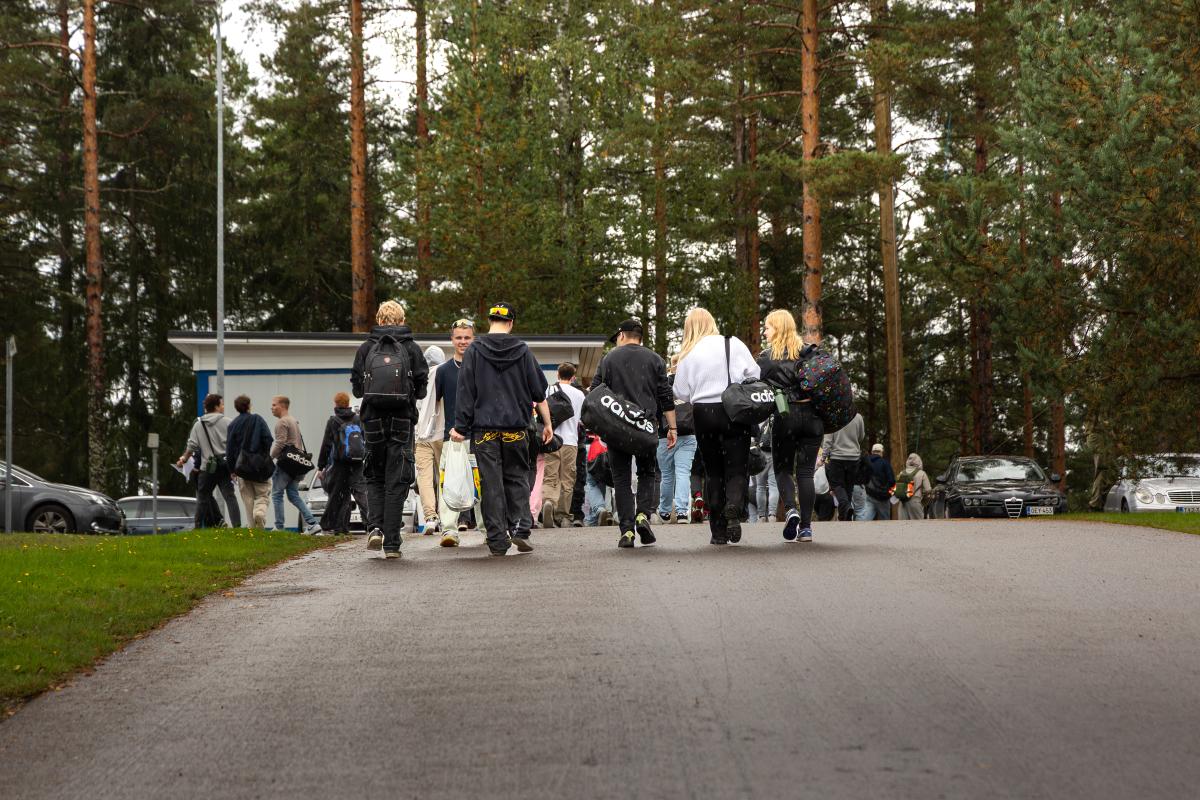 Kotiutuvia varusmiehiä kävelemässä kohti varuskunnan uloskäyntiä.
