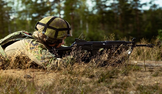 Naissotilas ampumaharjoituksessa metsässä