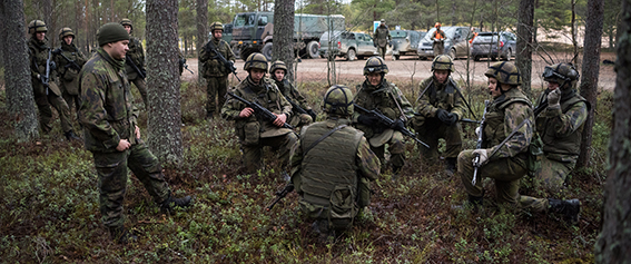 Sotilaat metsässä korkeassa polviasennossa käskynannossa