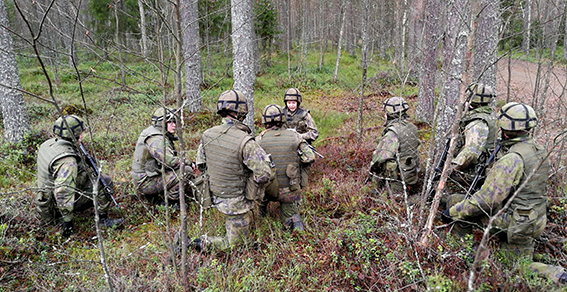 Sotilaat metsässä korkeassa polviasennossa käskynannossa