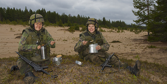 Kaksi sotilasta ruokailevat metsässä