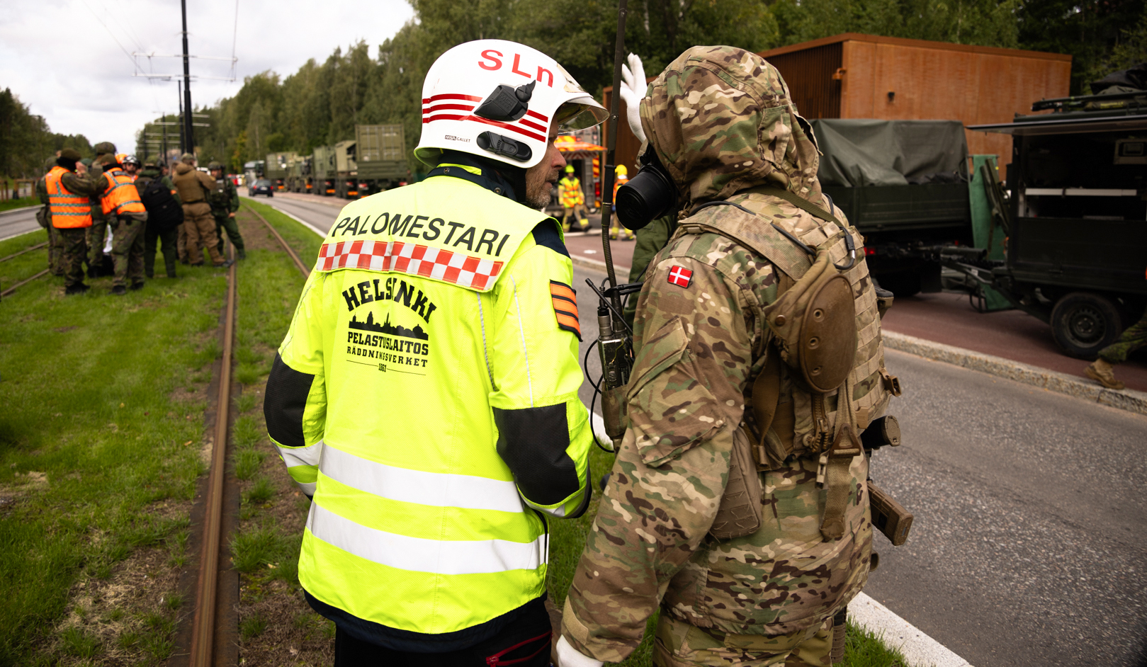 En brandchef och en dansk soldat som förhandlar. Resten av träningsgruppen syns i bakgrunden. 