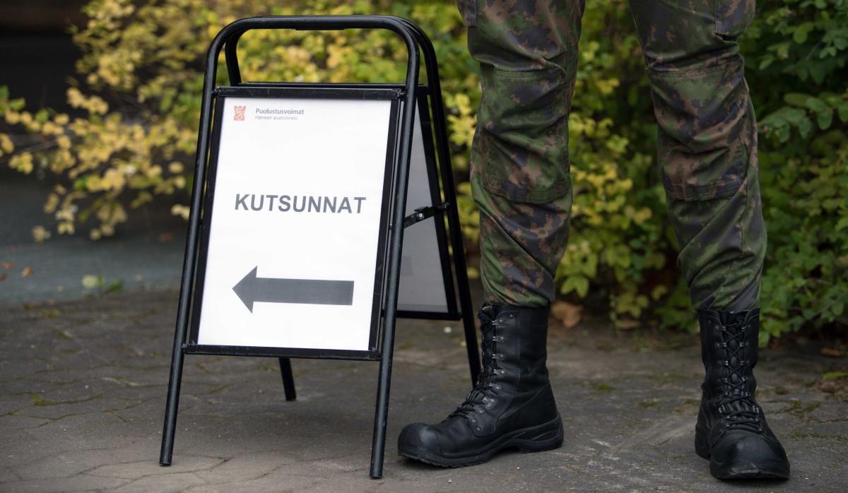 Sotilas seisoo kyltin vieressä jossa lukee: