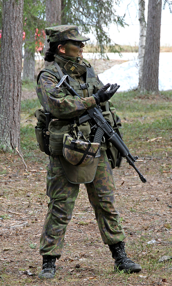 The female soldier in combat equipment explains something