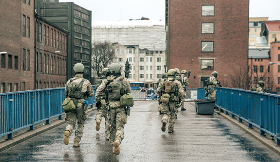 Soldater som korsar en bro i staden