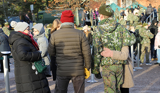 Varusmiehiä ja heidän läheisiään talvivaatteissa Santahaminassa ulkona.