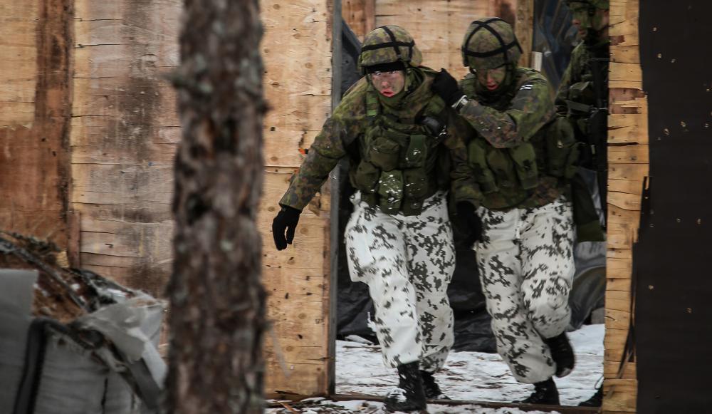 Kolme sotilaspoliisivarusmiestä perääntymässä rakennetun alueen taistelun harjoituksessa.