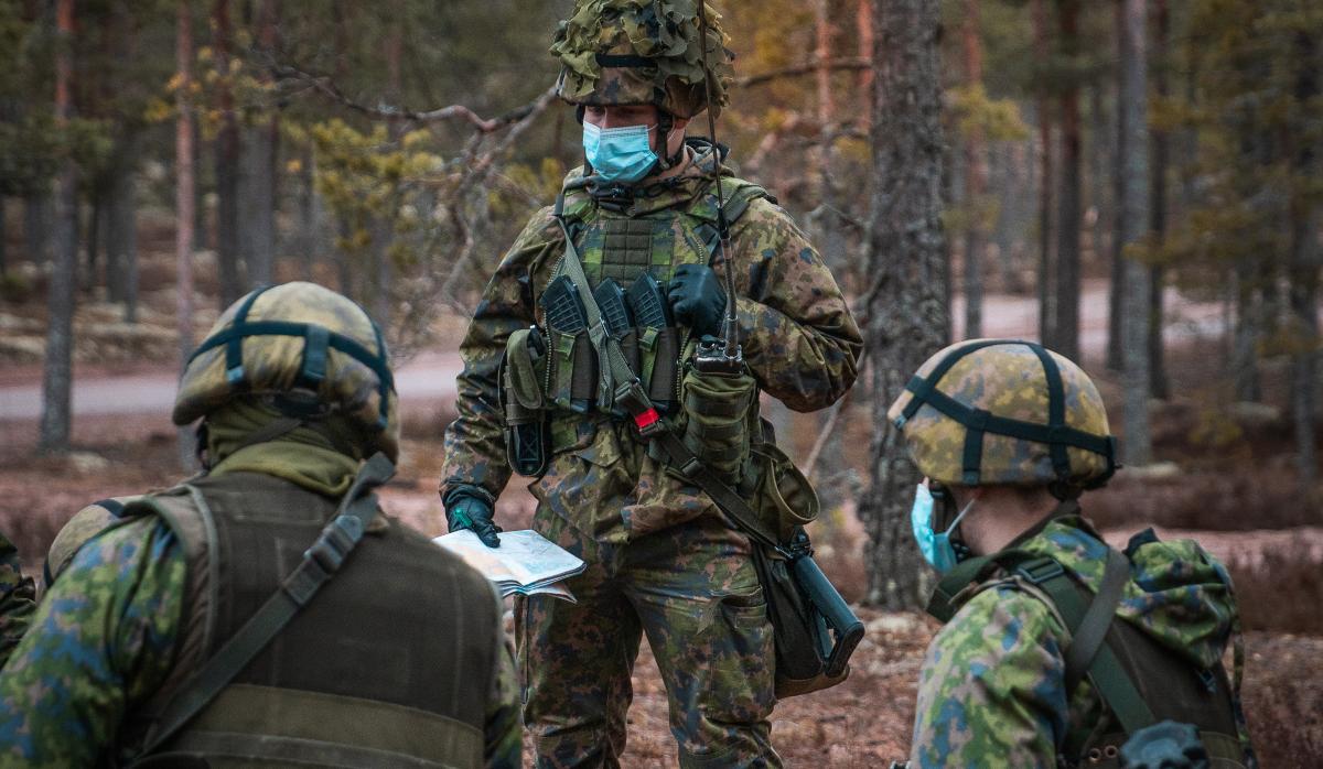 Kuvassa tehtävänantoa, etualalla kaksi sotilasta polviasennossa ja takana yksi sotilas seisten.