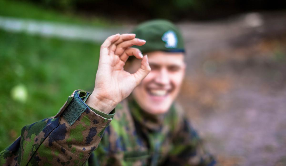 Sotilas näyttää iloisena nollaa sormillaan