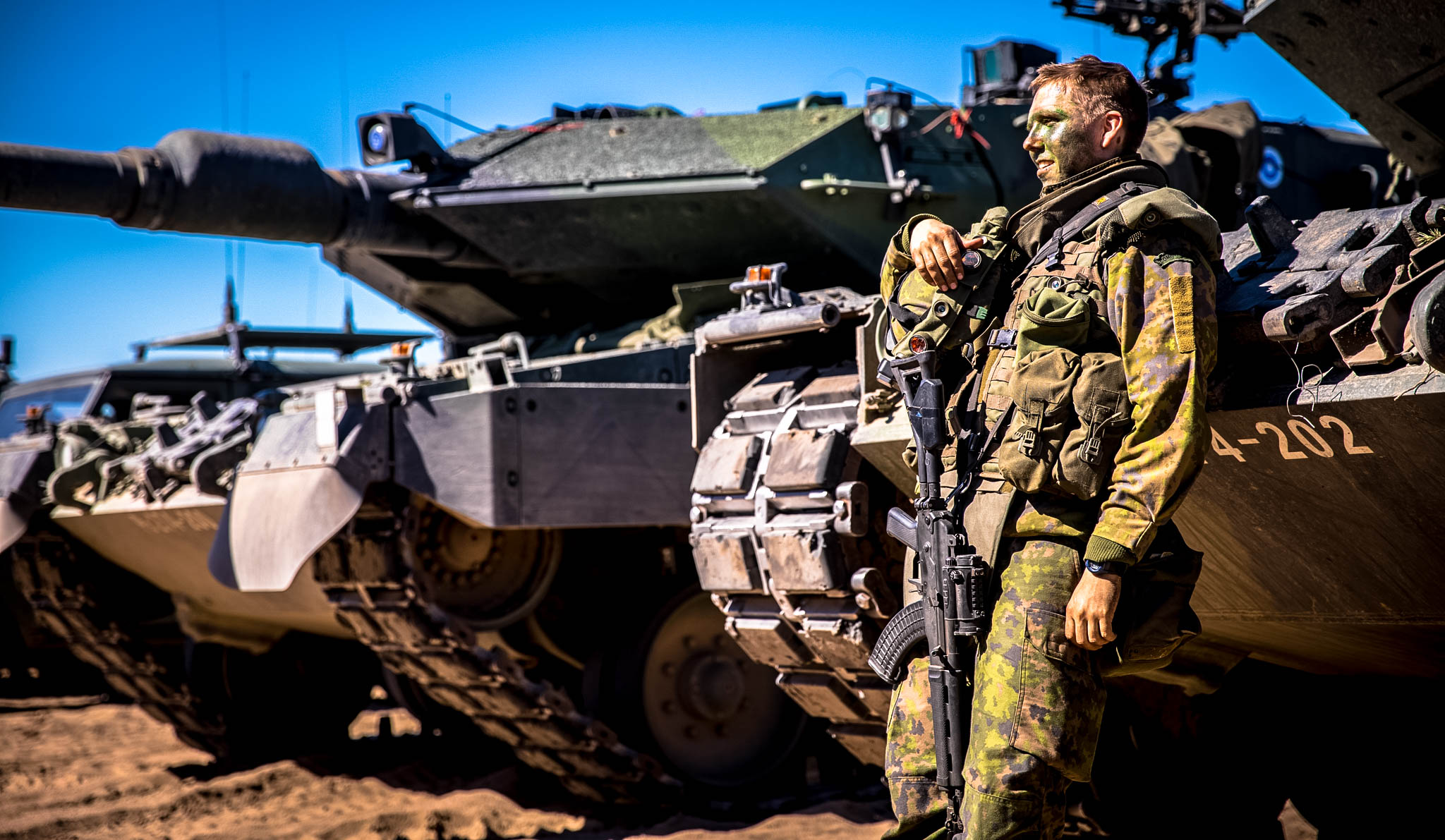 The soldier is leaning on the tank