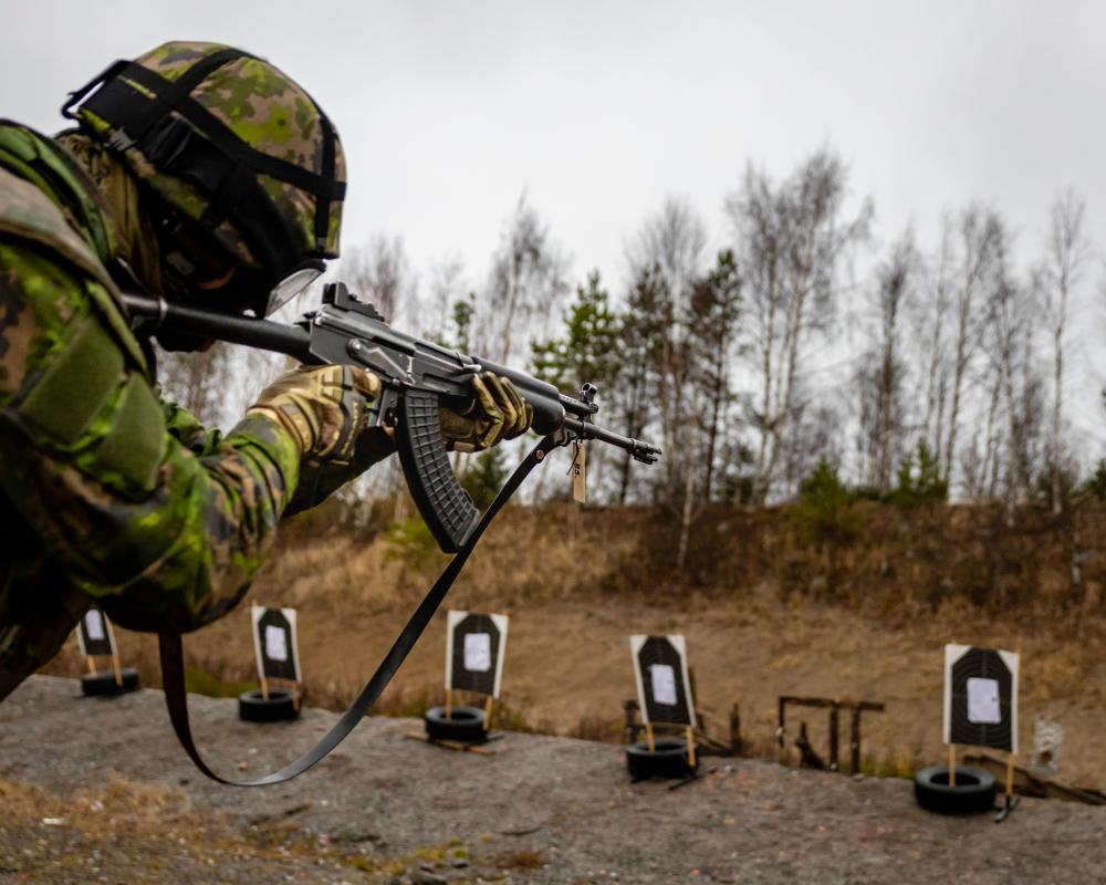 Kuva jossa reserviläinen on ampumaradalla ampumassa rynnäkkökiväärillä.