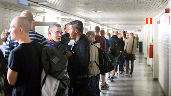 Unga män uppradade med ryggsäckar