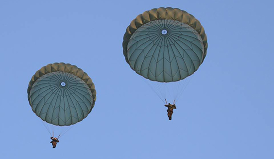 Two paratroopers landing on parachutes