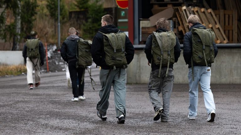 Kotiutuvia varusmiehiä kävelee siviilivaatteissa poispäin kamerasta